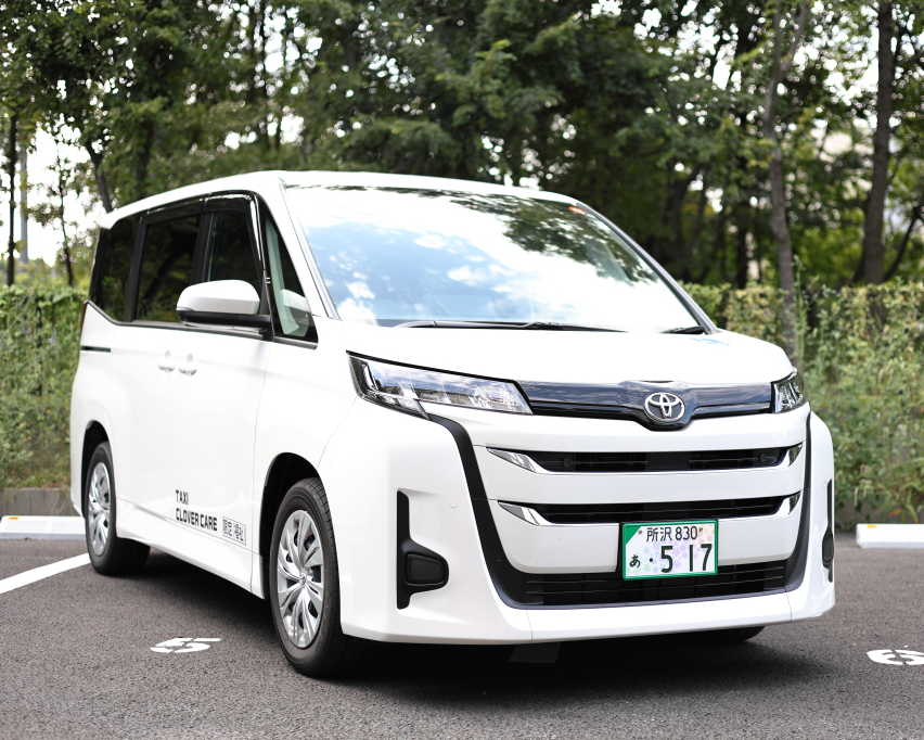 ノアの外観の写真、白い車体。側面にはtaxi clover careと文字が入っている。